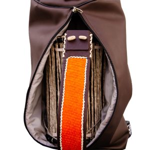 Brown backpack with open zipper showing contents, featuring orange and white braided strap.
